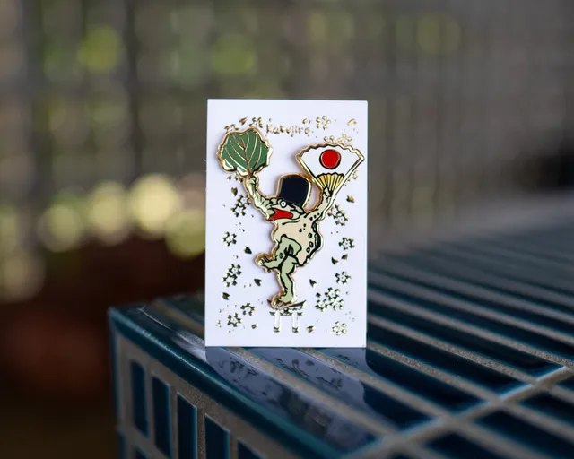 kabujiro-waving-frog-emaille-pin-animal-circus-50x61mm image 1